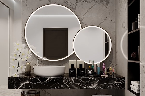 Two circular illuminated mirror with white basin and cosmetics under the black porcelain table.