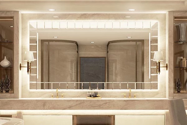 Wall lampshade on either side of a unique backlit mirror over the double sinks in a bathroom.