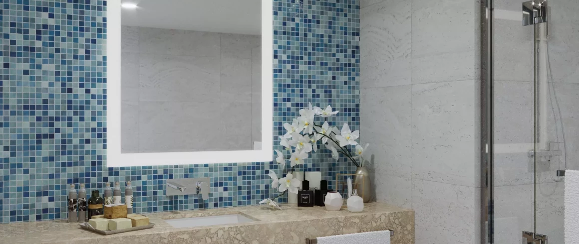 Frosted light-framed mirror installed in a blue mosaic tiled wall with white flowers.