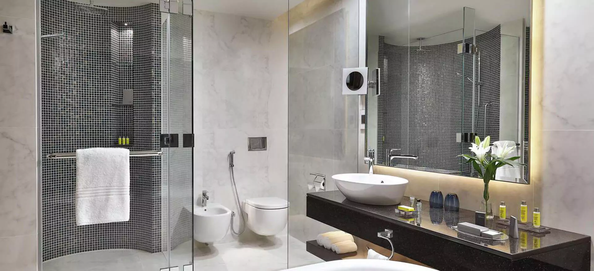 Exquisite wall-mounted backlit mirror in a classy bathroom.
