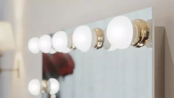 A frosted light bulb with a gold ring built into a unique mirror.