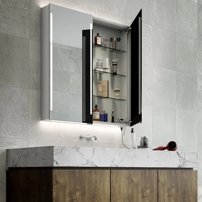 Cabinet with an LED mirror door and cosmetics inside, installed in a tiled wall above a single sink.