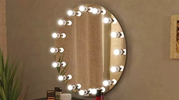 Circular Hollywood mirror mounted on a brown wall.